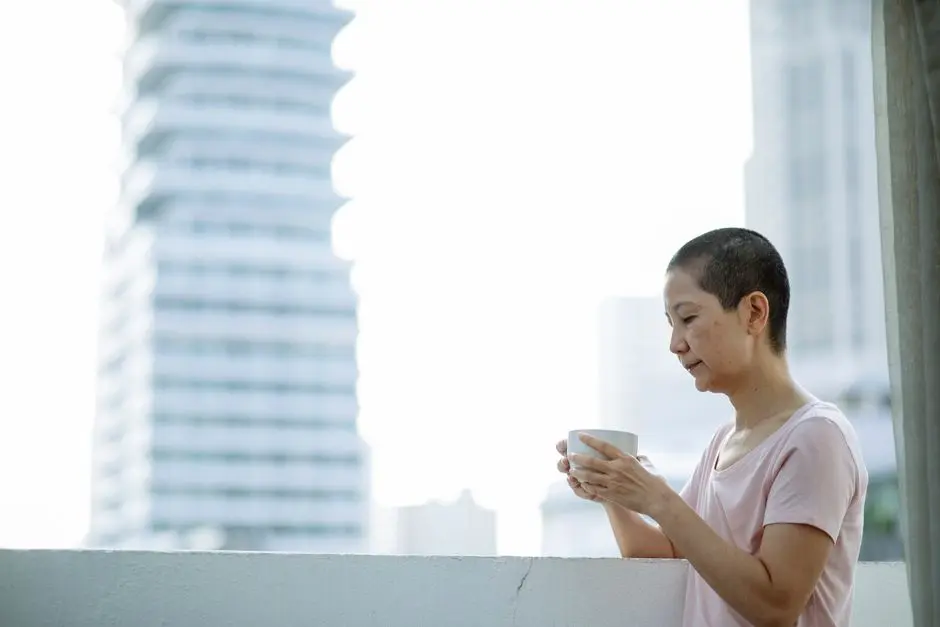 Wanita duduk di teras rumah di pagi hari sambil minum kopi